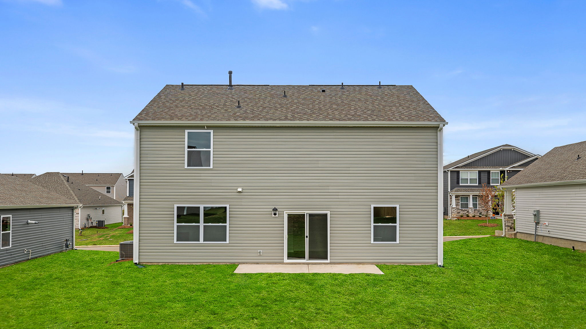 Back exterior of the Belhaven home with large backyard and patio.