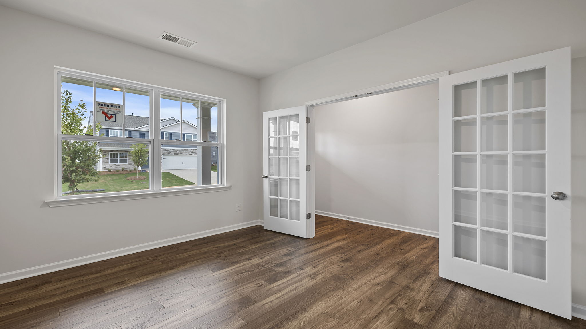 Study is located at the front of the home with large window and accented by French doors.