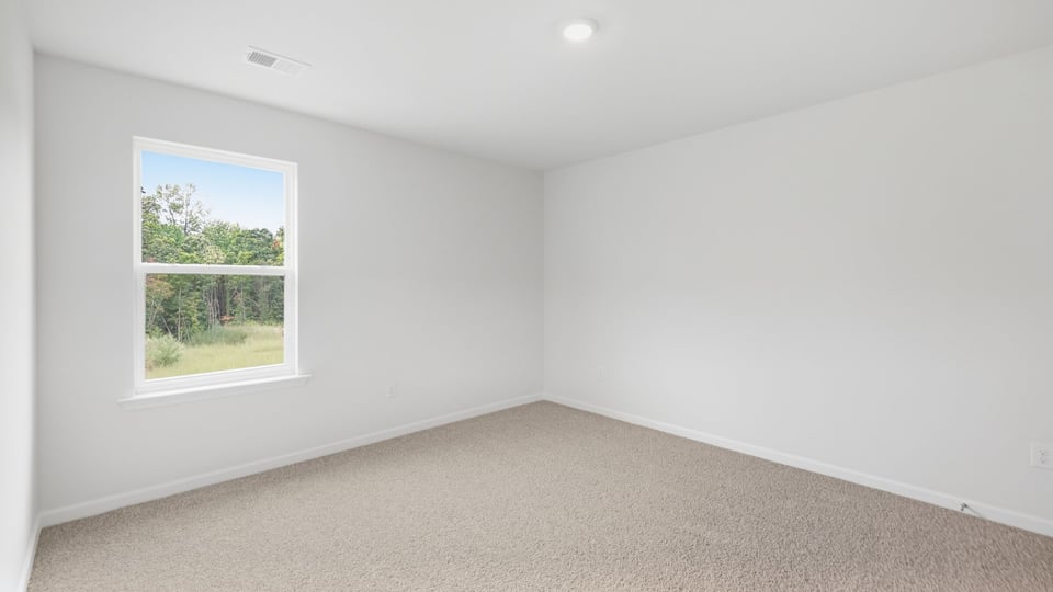Bedroom with carpet and windows.