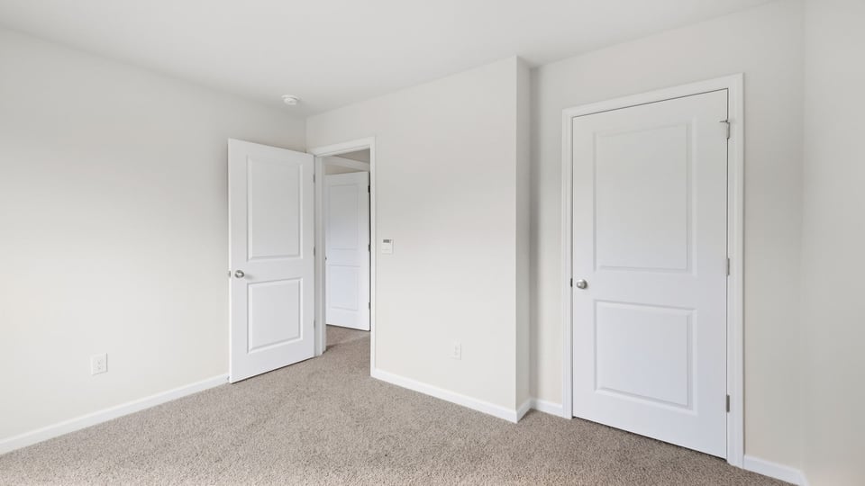 Bedroom with carpet and windows.