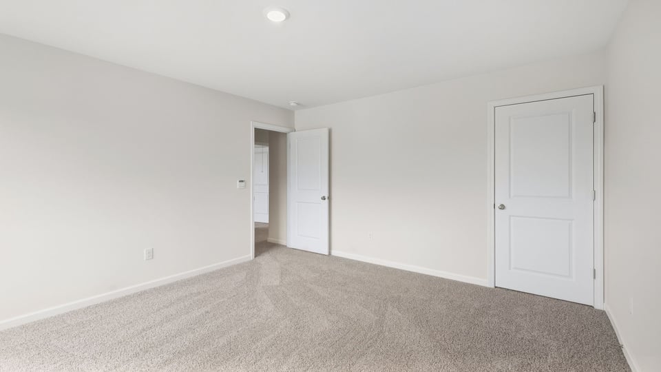 Bedroom with carpet and windows.
