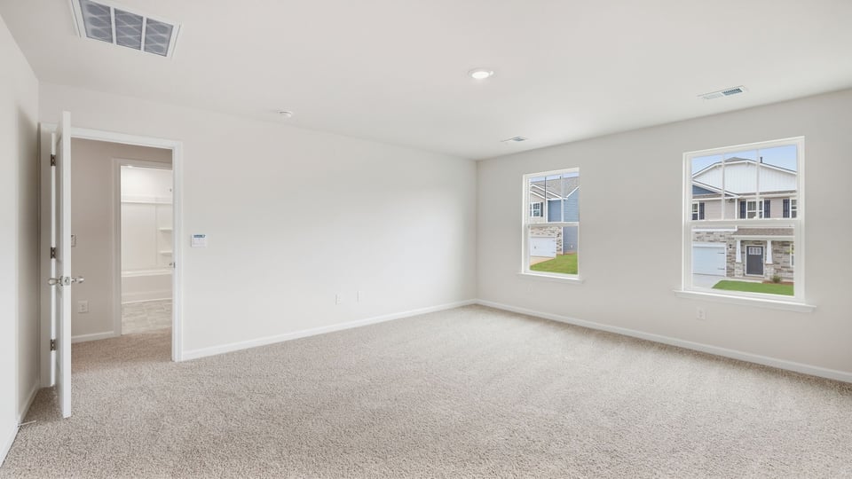 Bedroom with carpet and windows.