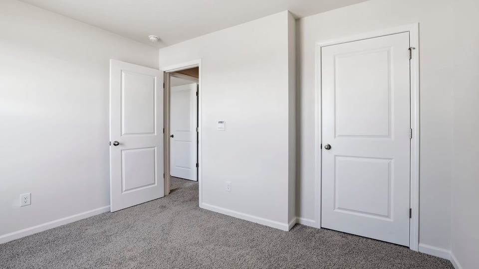 Bedroom with carpet and windows.
