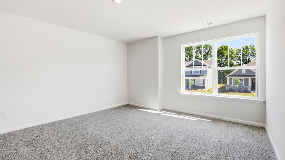 Bedroom with carpet and windows.