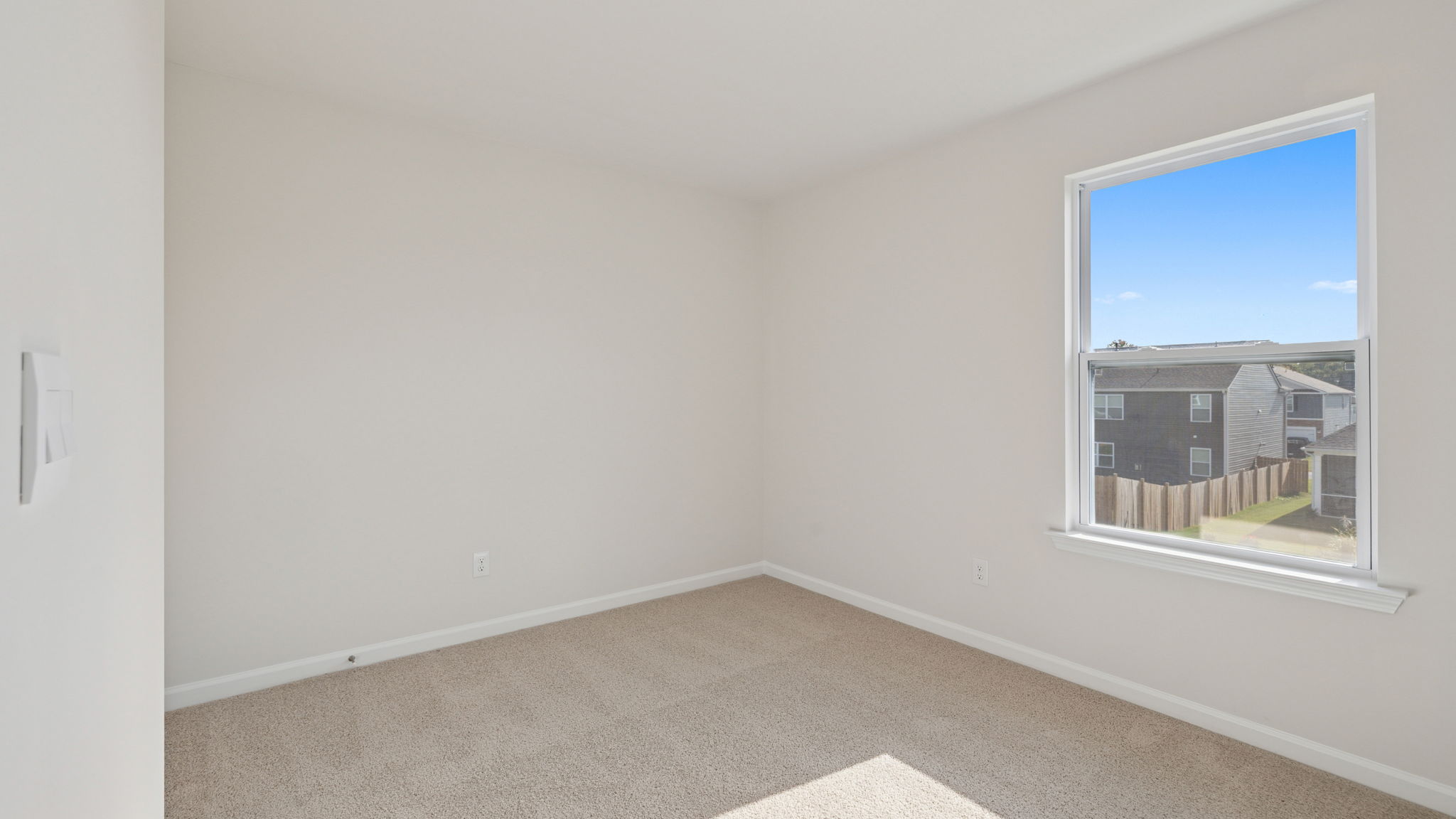 Bedroom with large window and carpet.