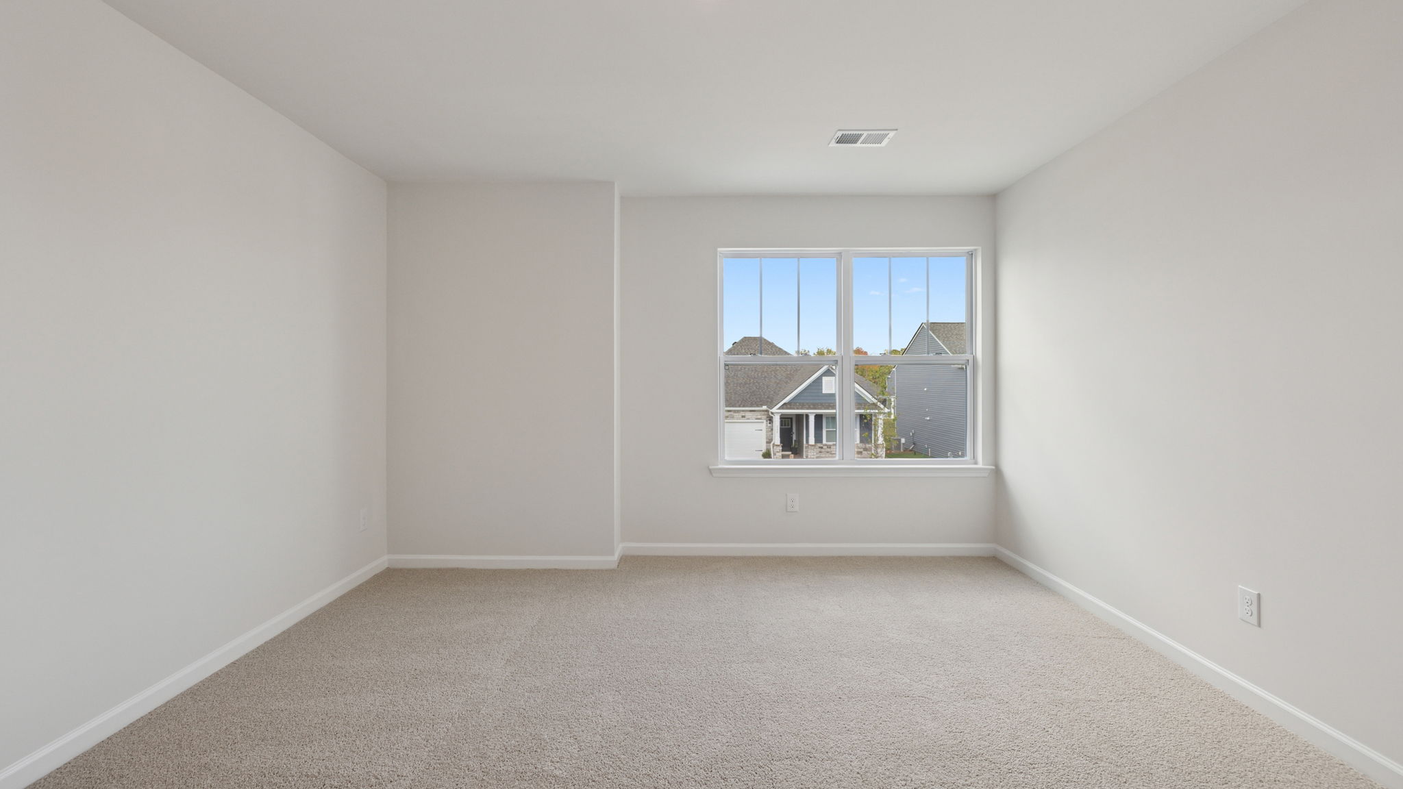 Bedroom with large window and carpet.