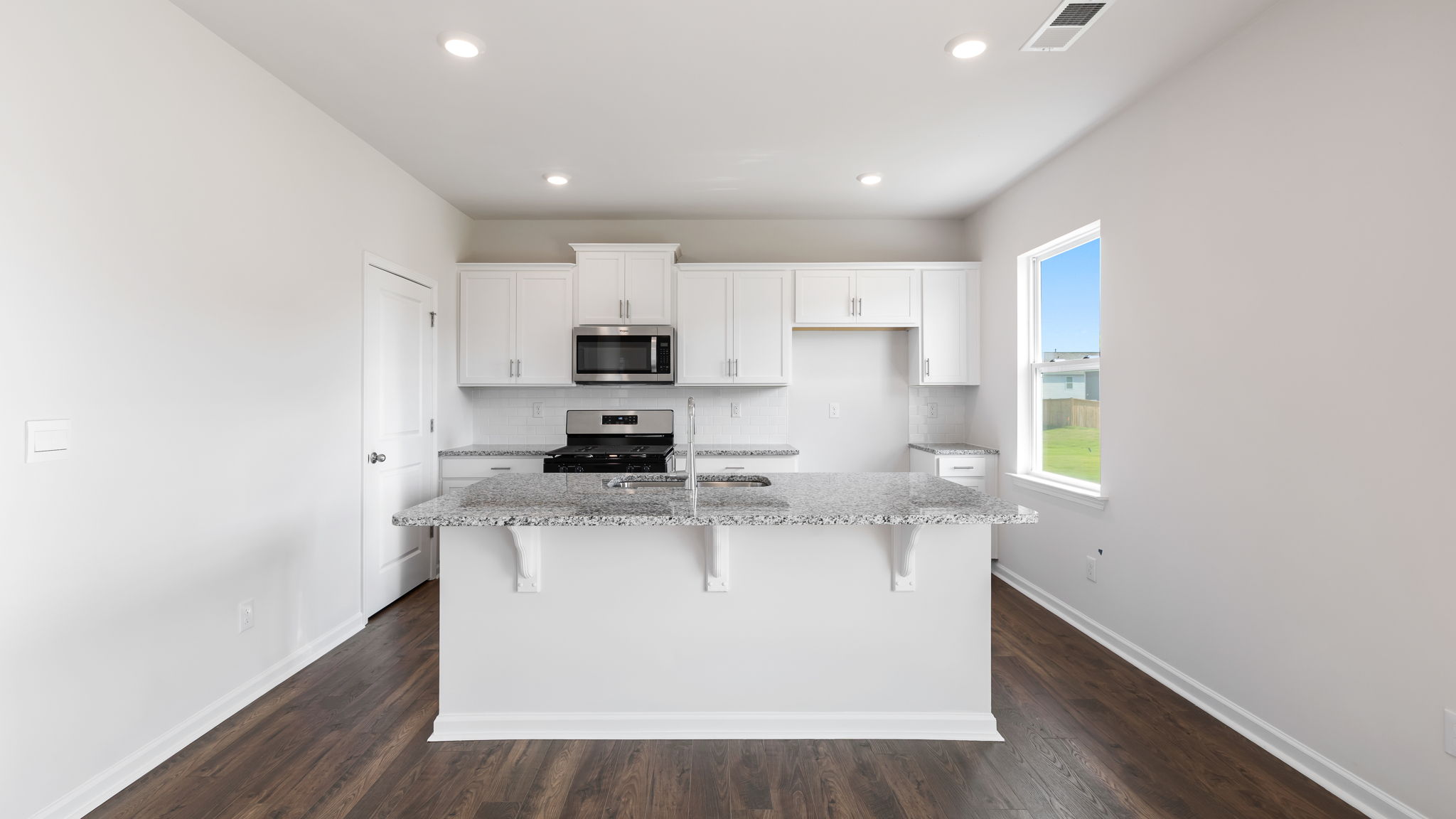 View of kitchen with island, recessed lighting and window.