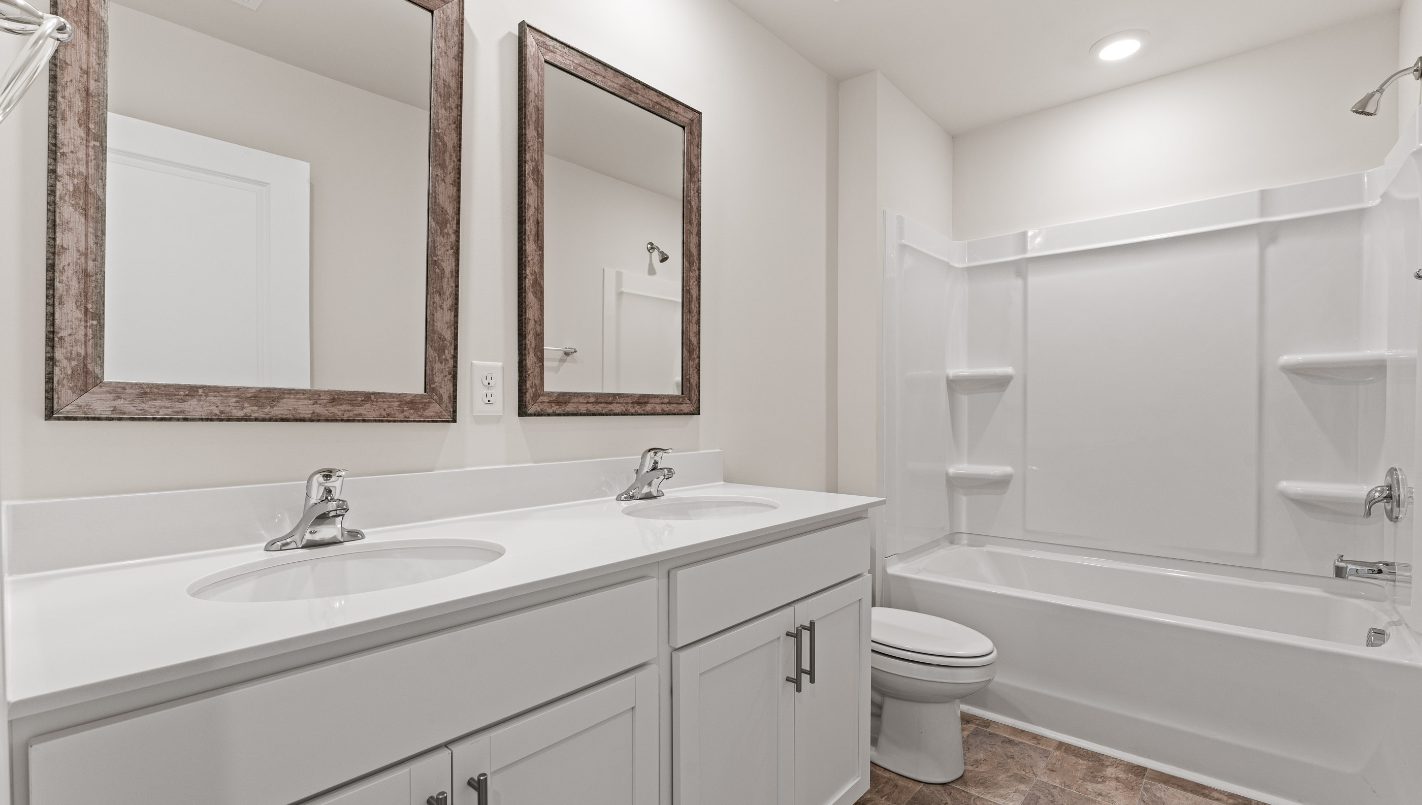 Hall bathroom with dual sink vanity and shower / tub.