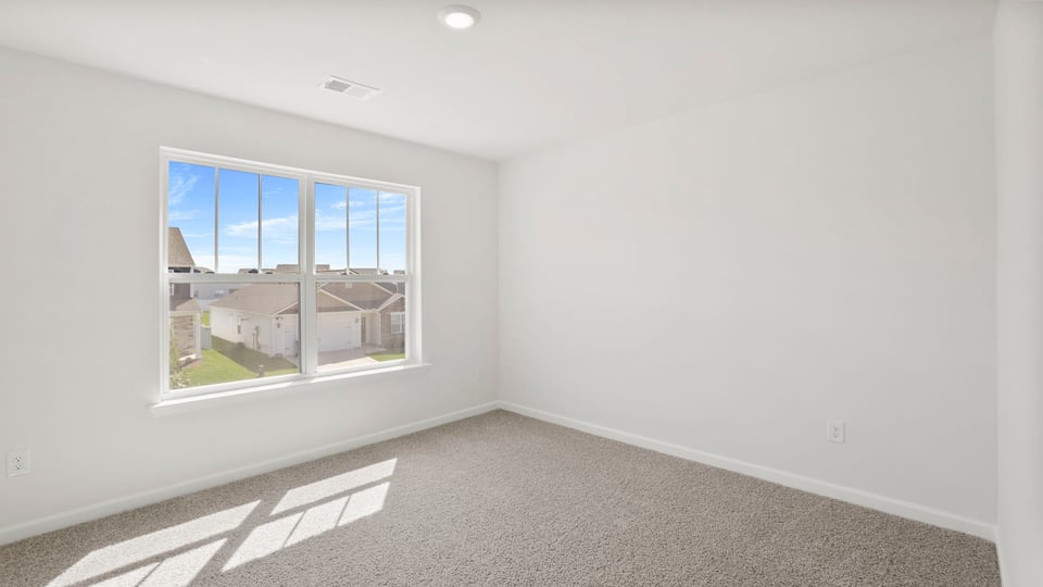 Bedroom with carpet and window.