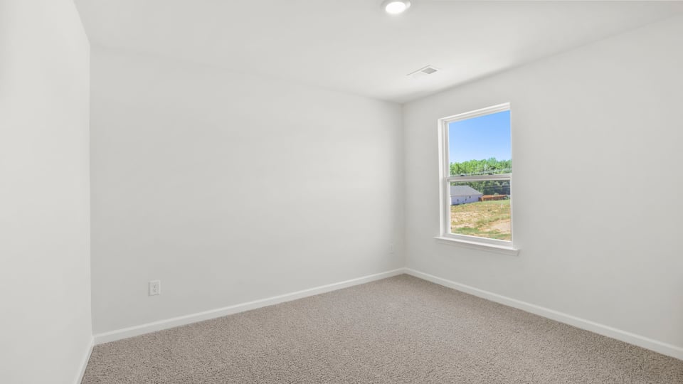 Bedroom with carpet and window.