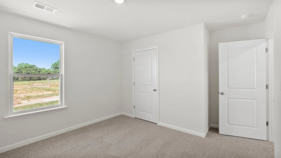 Bedroom with carpet and window.