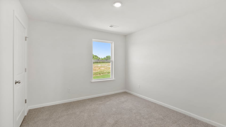 Bedroom with carpet and window.