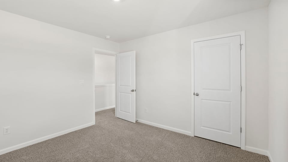 Bedroom with carpet and window.