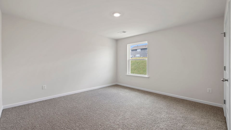Bedroom with window and carpet.