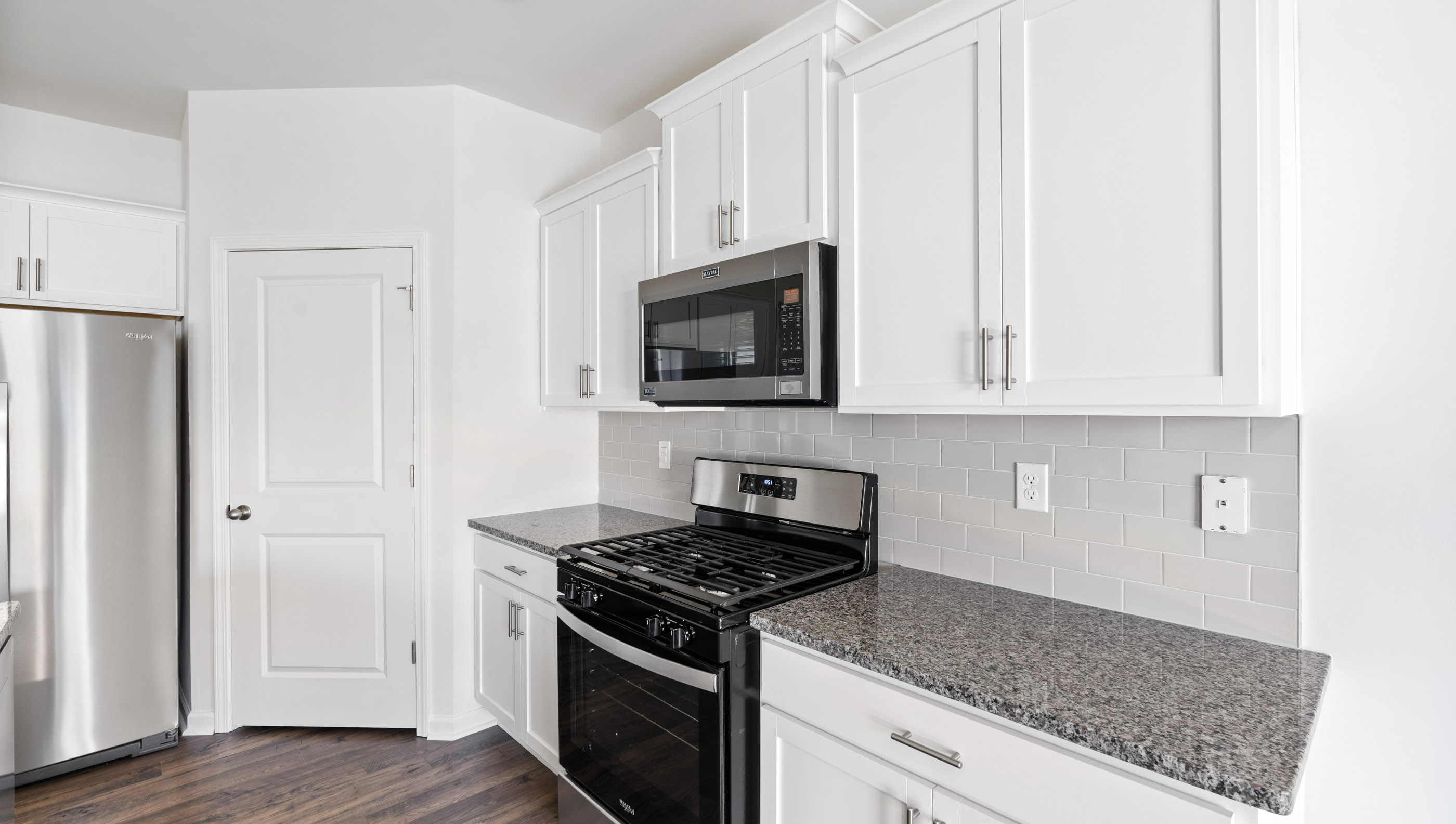 White cabinetry and stainless steel appliances.