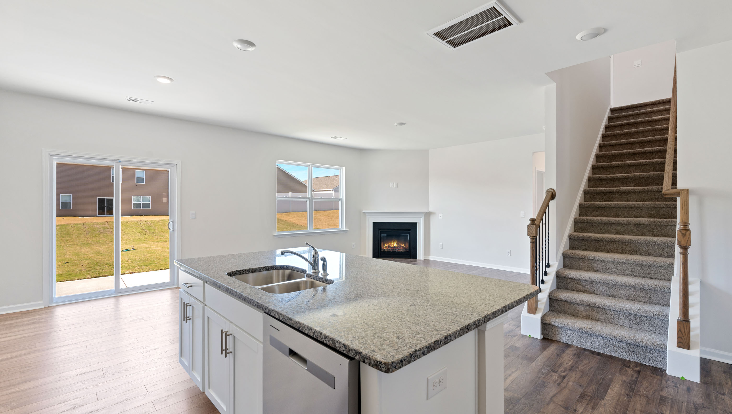 View from kitchen of family room and staircase to the upper level.
