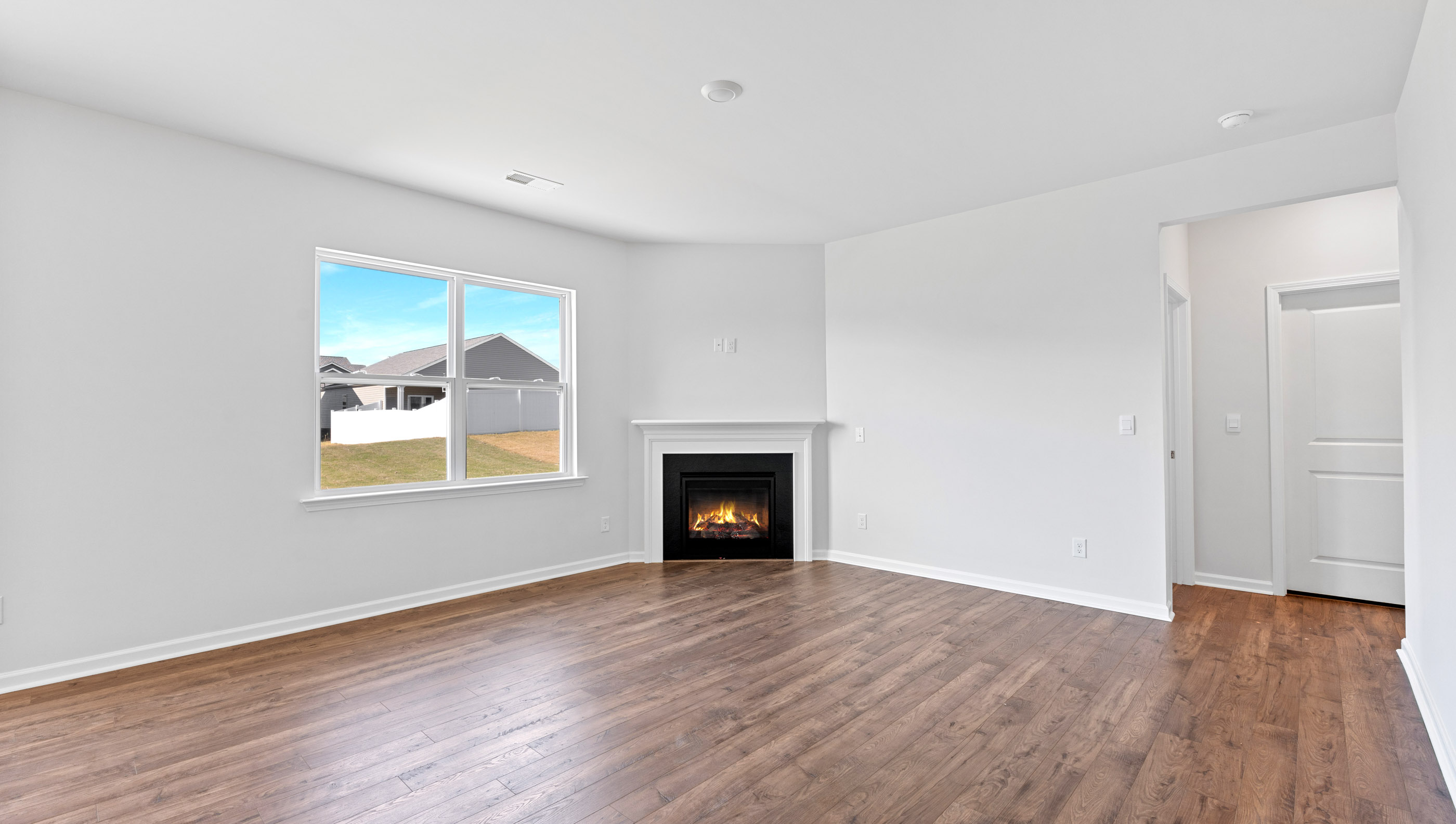 Family room with large window and gas log fireplace.