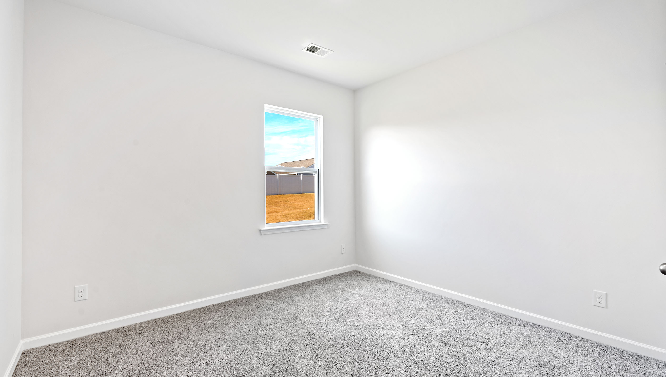 Bedroom on main level with window and carpet.