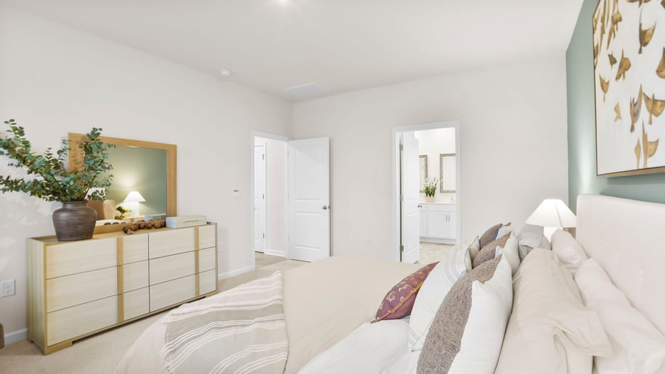 Primary bedroom with carpet and window.