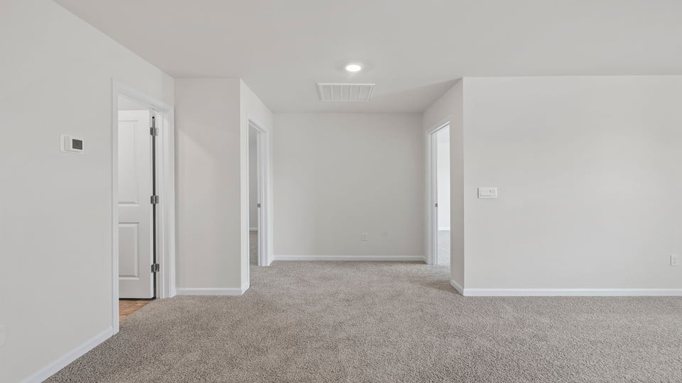 Loft area with carpet and windows.