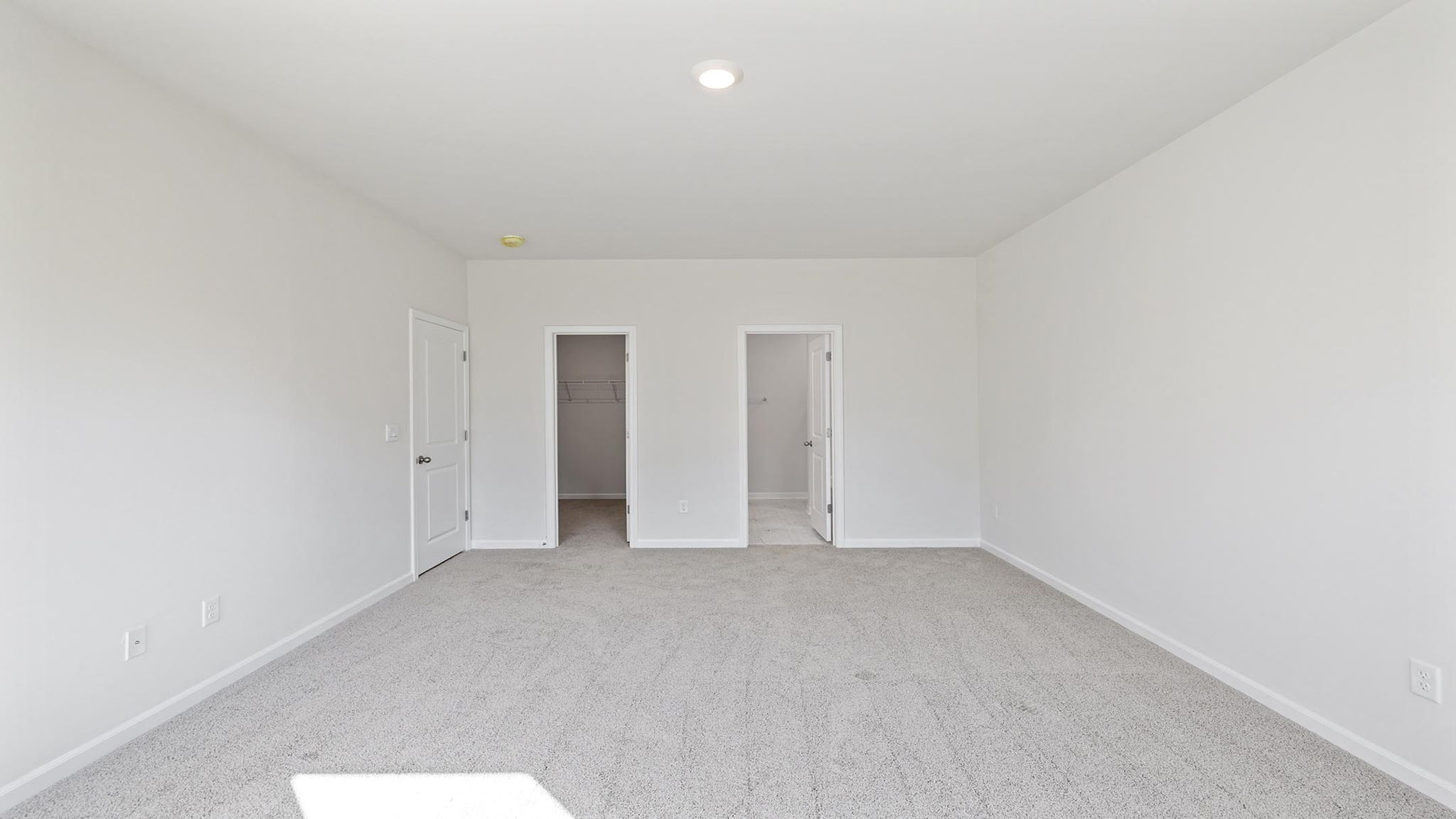 Primary bedroom with carpet.