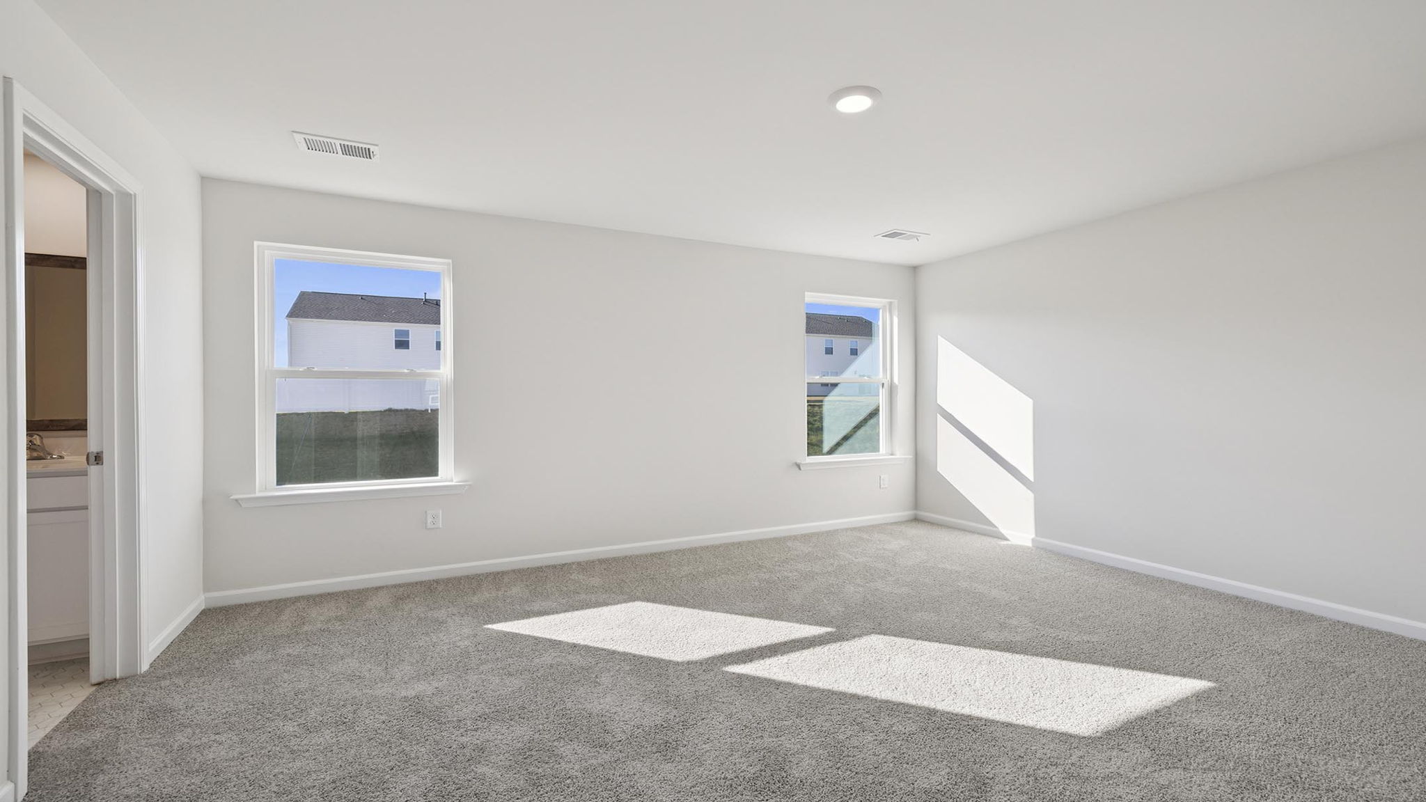Bedroom with carpet and windows.