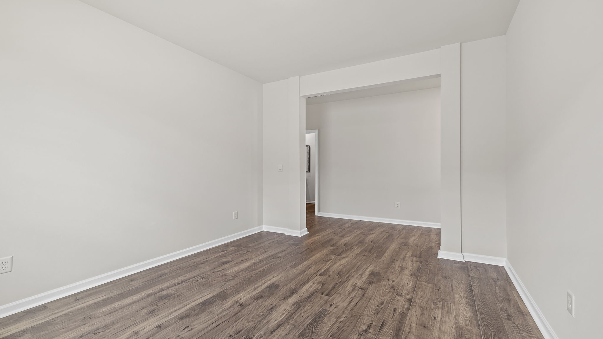 Formal dining room with window and laminate flooring.