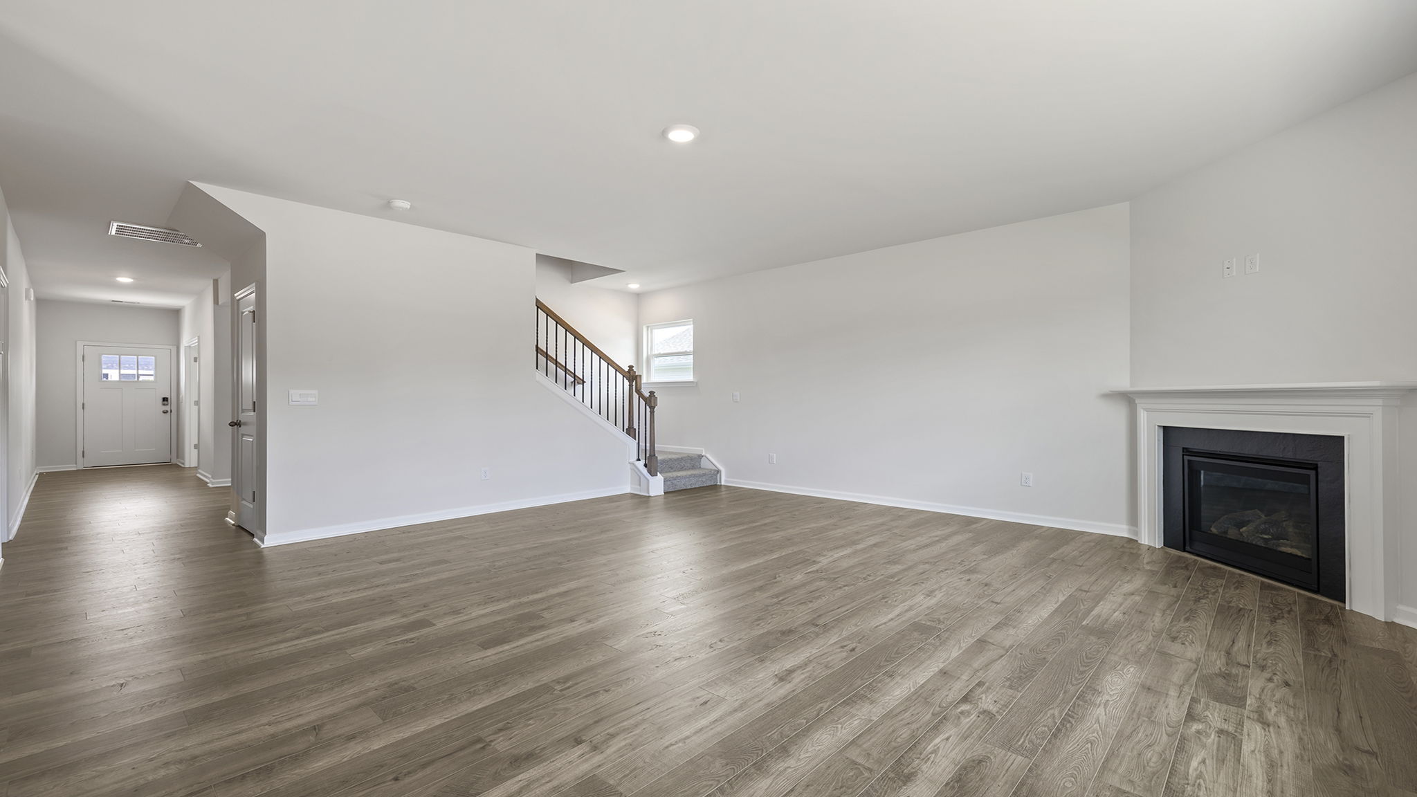 Family room with gas log fireplace and view of the hallway toward entrance.