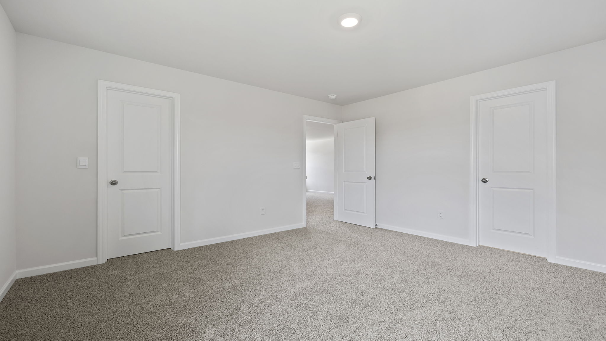 Primary bedroom with lots of windows and carpet.