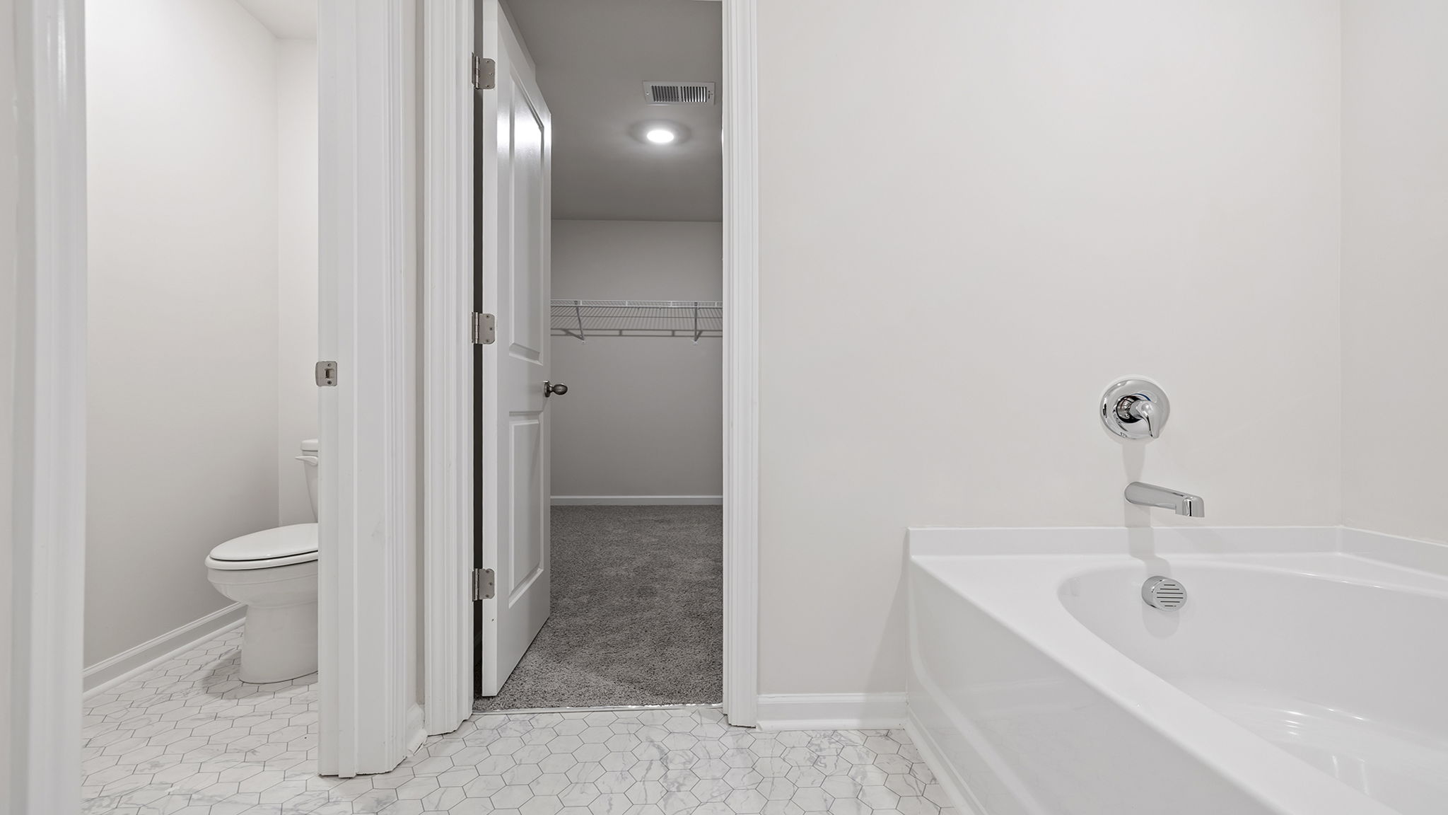 View of toilet area and entrance to walk-in closet.