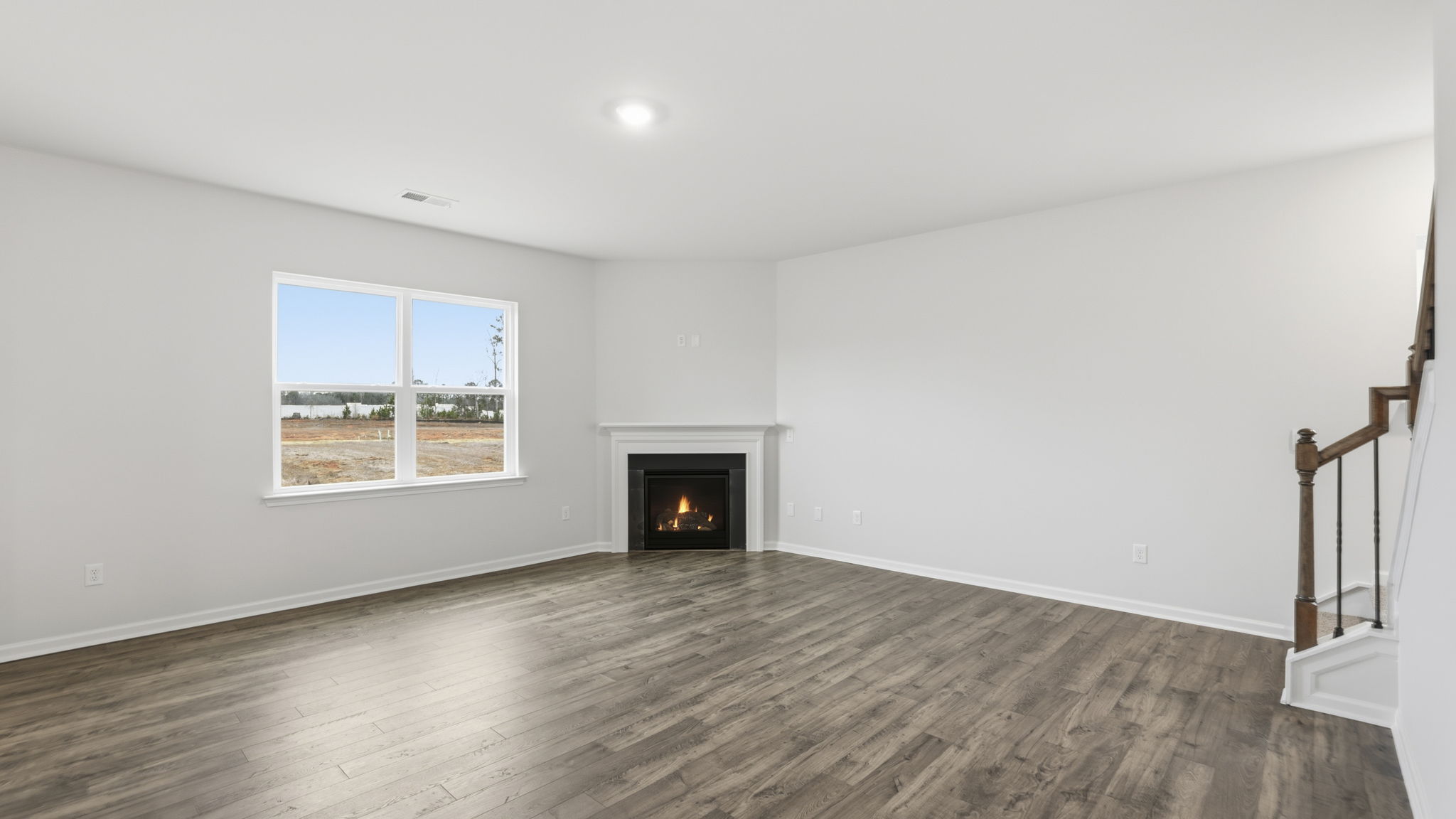 Family room with large window and gas log fireplace.