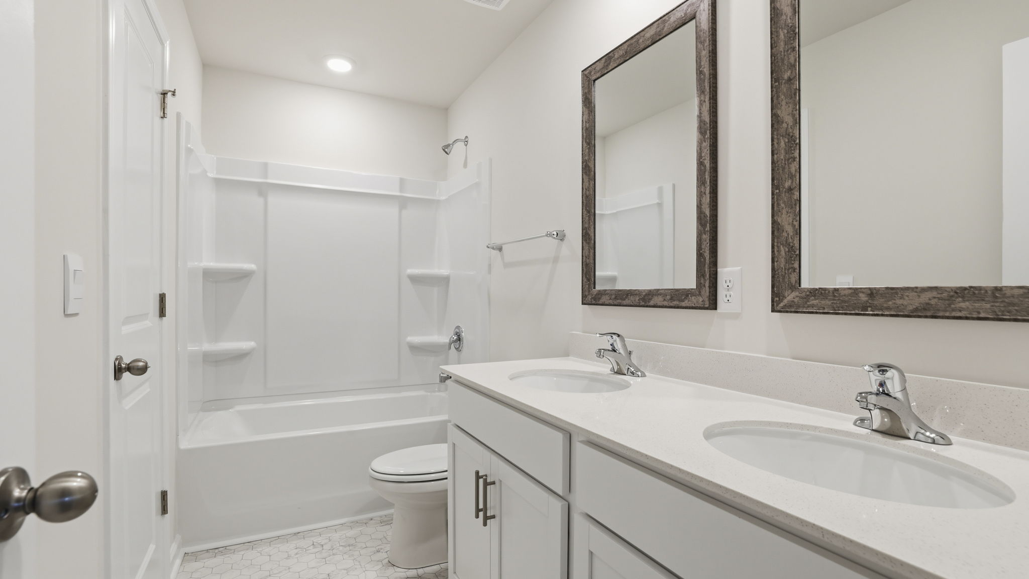 Hall bathroom with dual sink vanity and combination shower / tub.