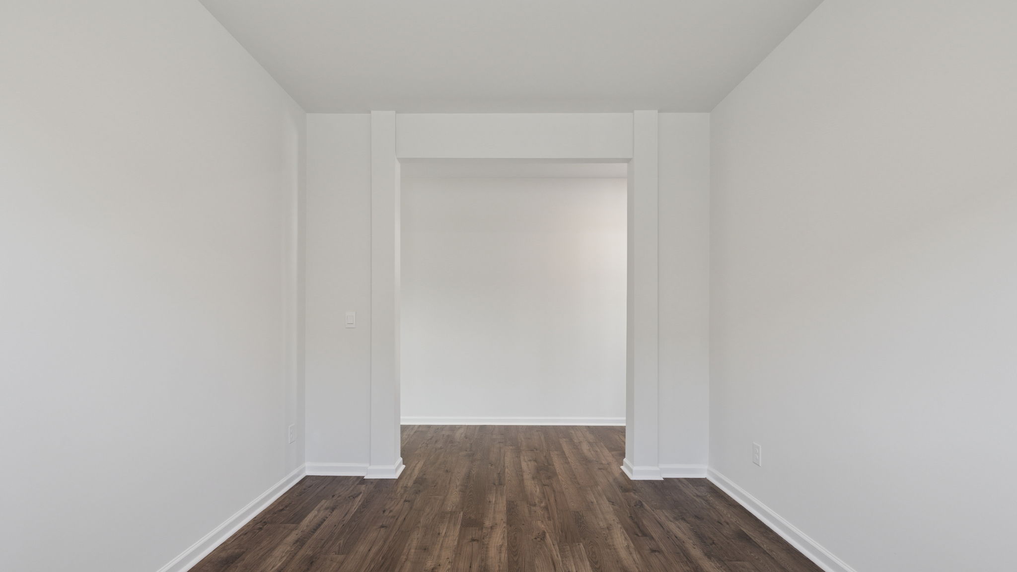 Formal dining room with window and laminate flooring.
