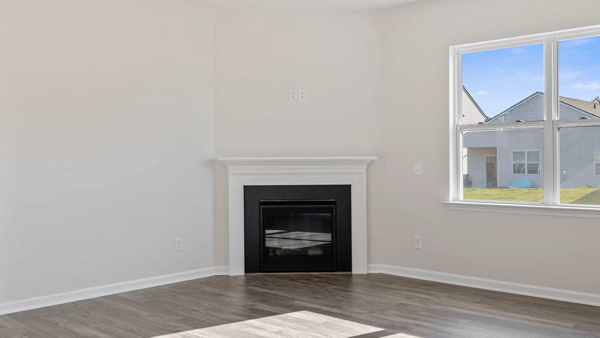 Family room with gas log fireplace and large windows.