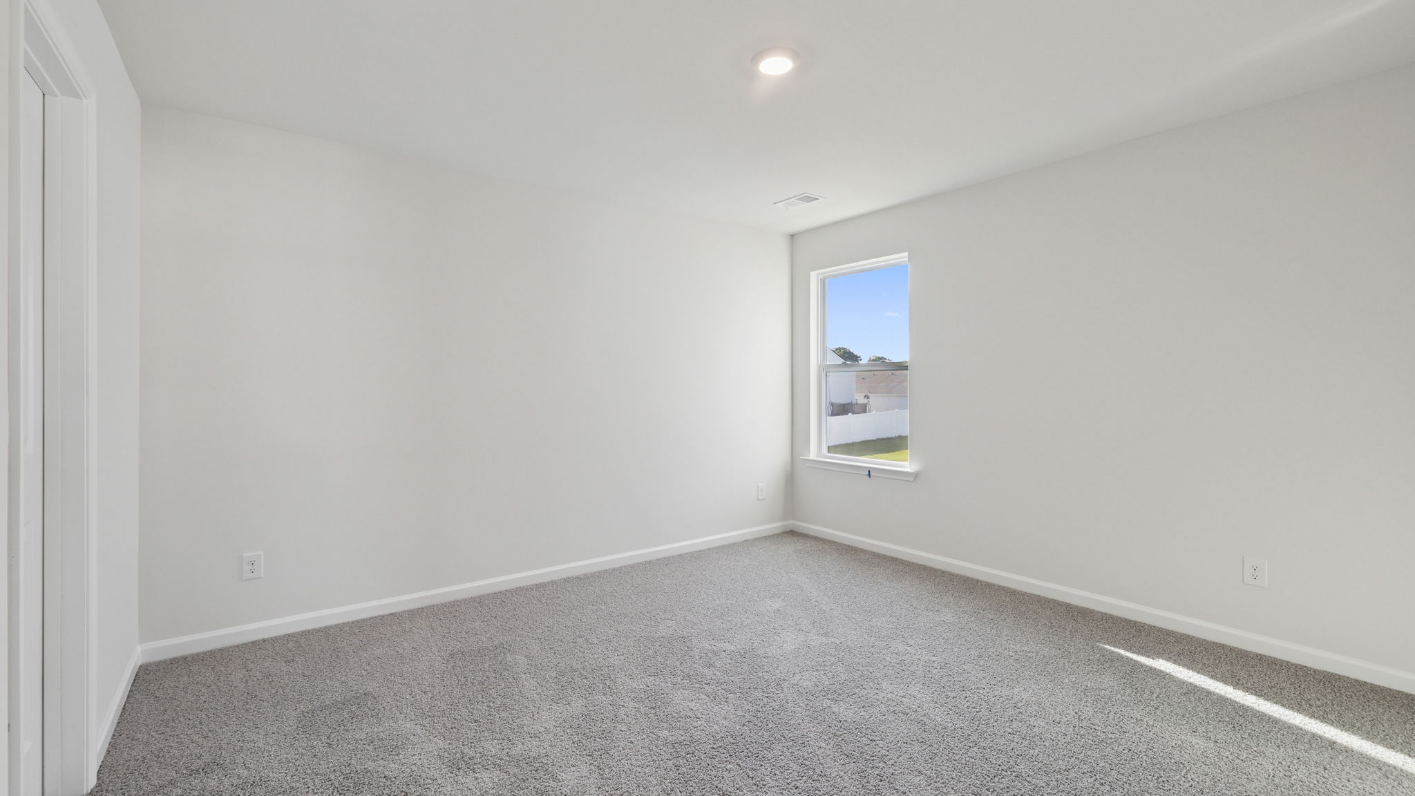 Bedroom with large window and carpet.
