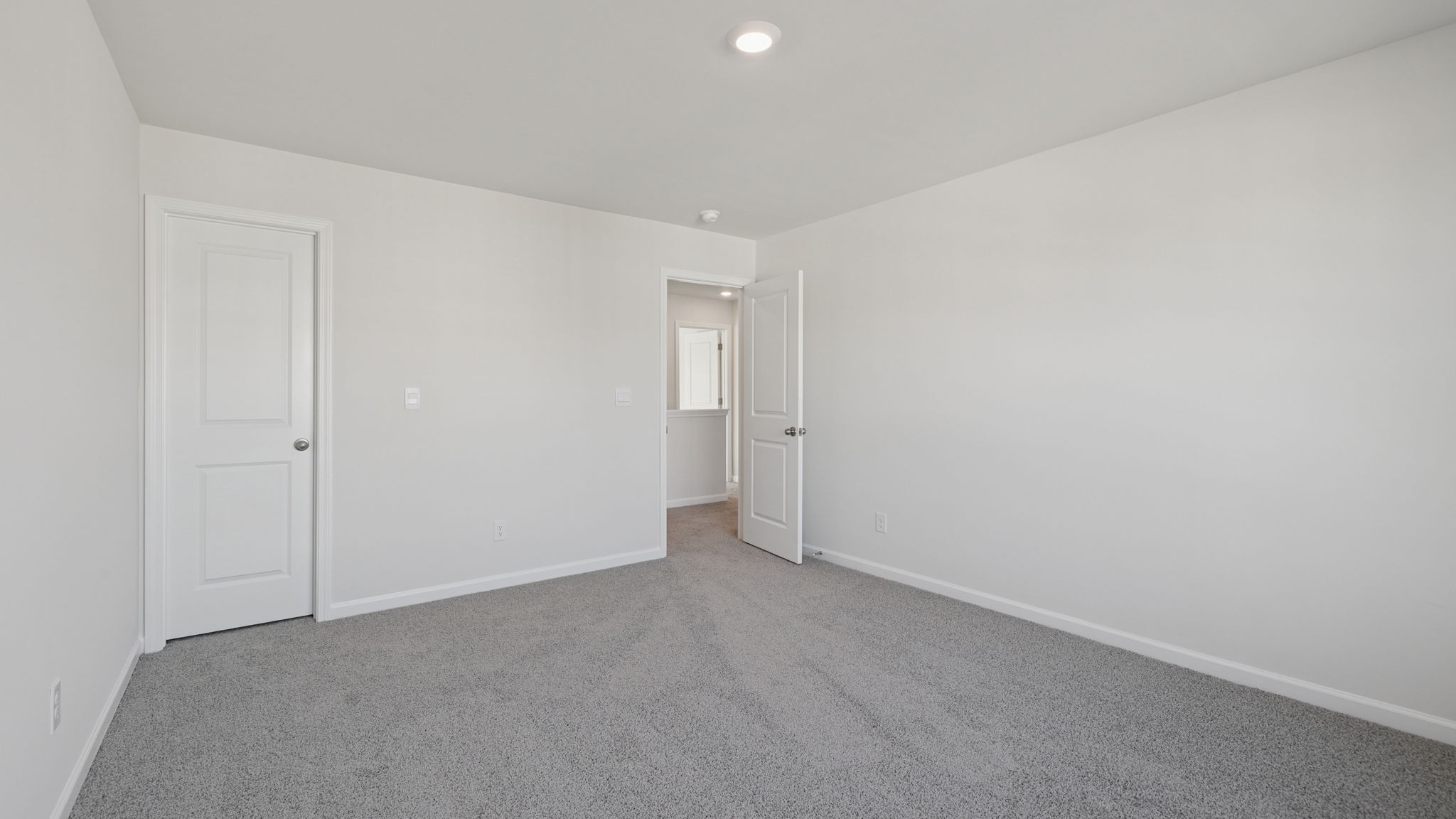 Bedroom with large window and carpet.