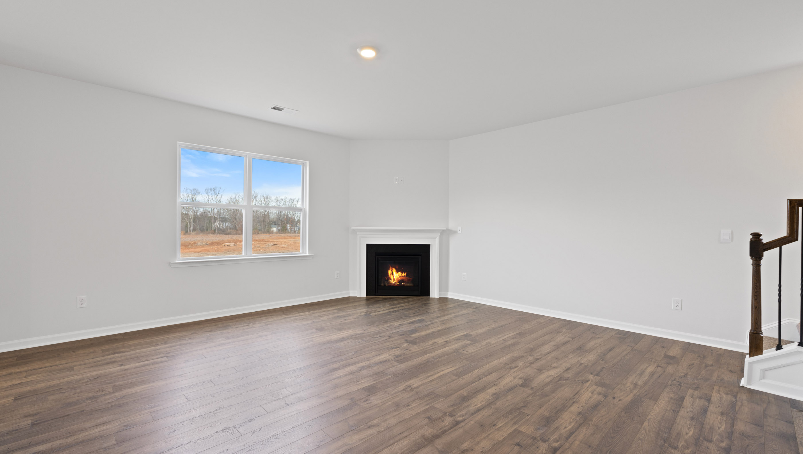 Family room with window and gas log fireplace.