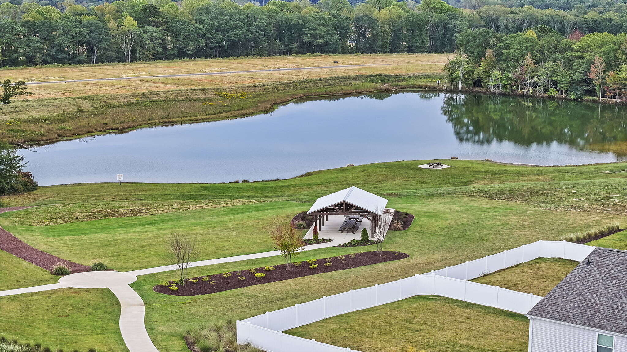 Walking trail and picnic area by a pond.