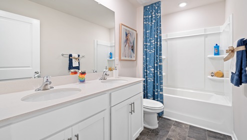 Bathroom with double vanity sink and tub.