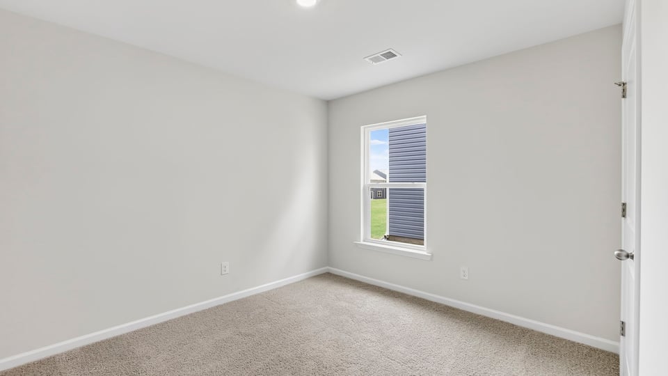 Bedroom with window and carpet.
