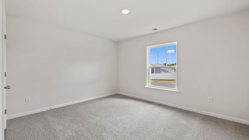 Bedroom with carpet and window.