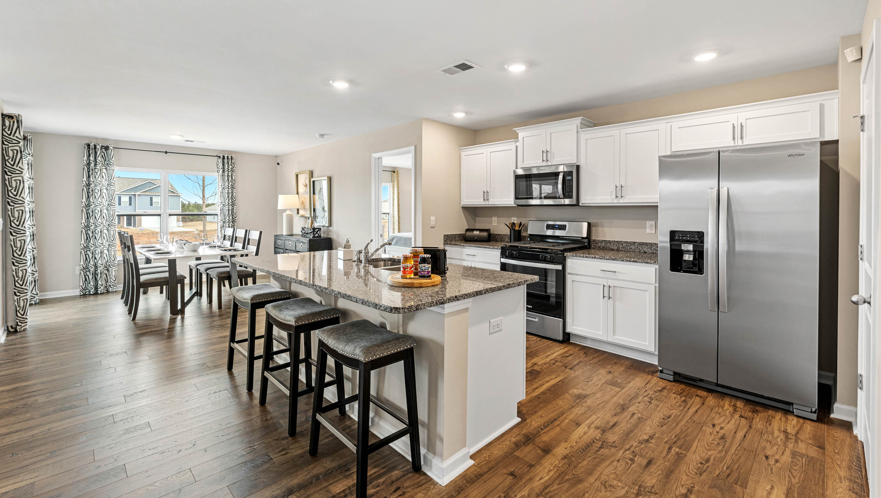 Kitchen and island with quartz countertops and stainless steel appliances.