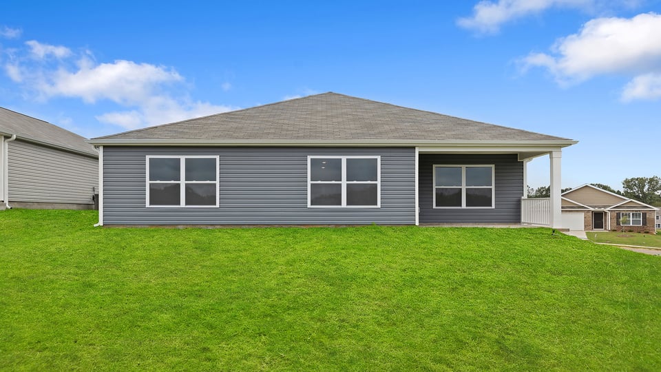 Back exterior of home with large backyard.