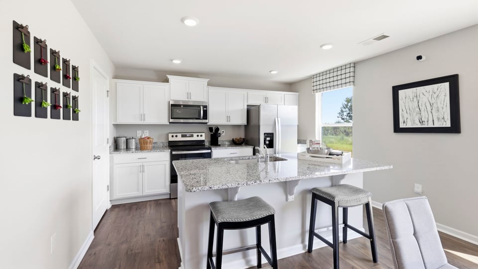 Kitchen and island with stainless steel appliances.