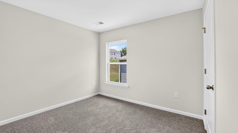 Bedroom with carpet and windows.