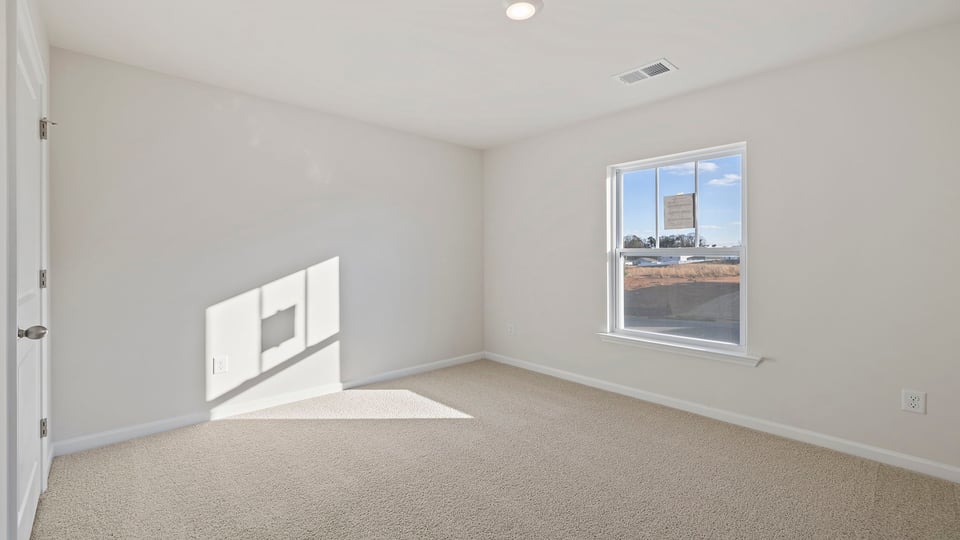 Bedroom with carpet and window.