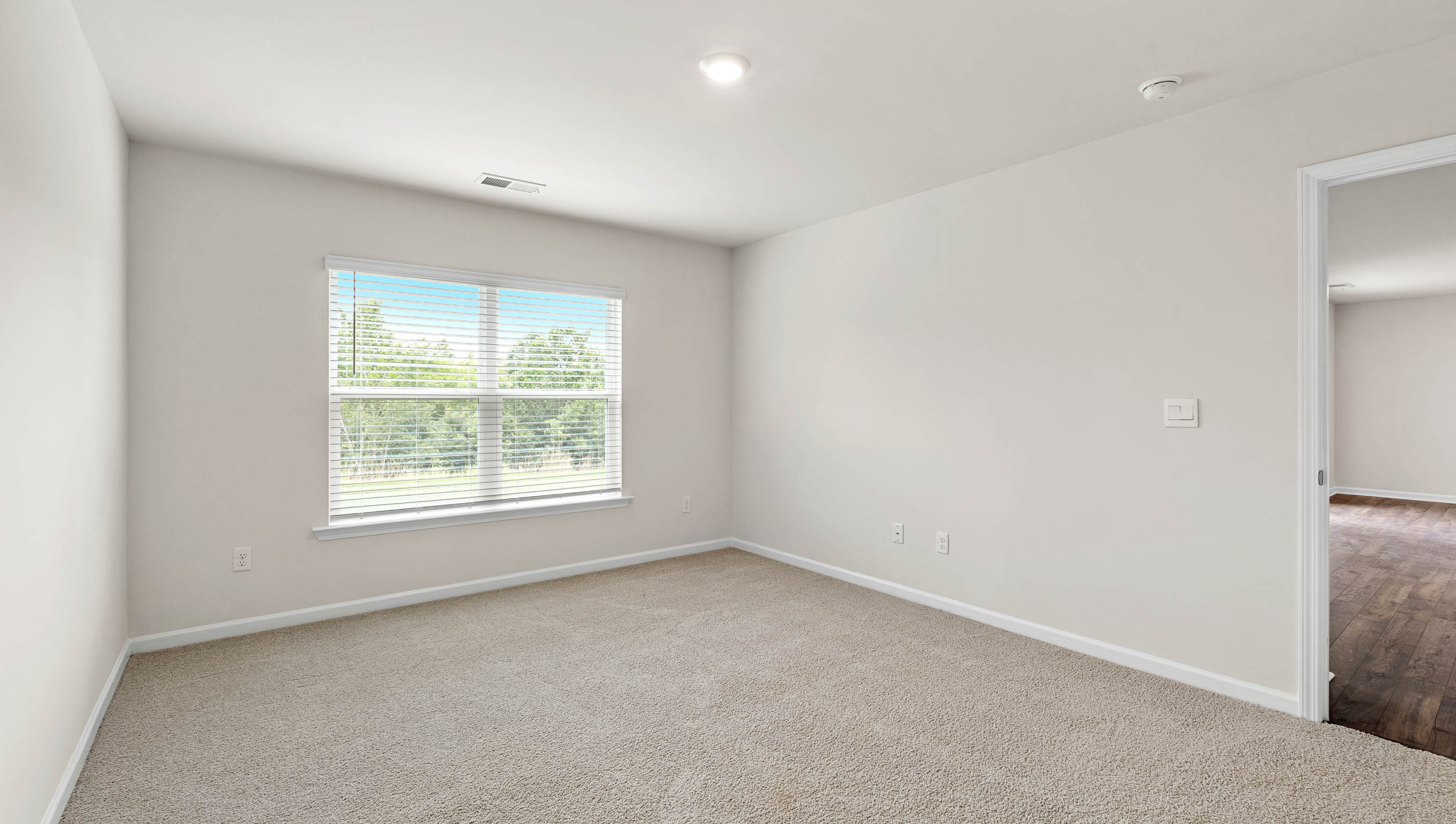 Bedroom with carpet and windows.