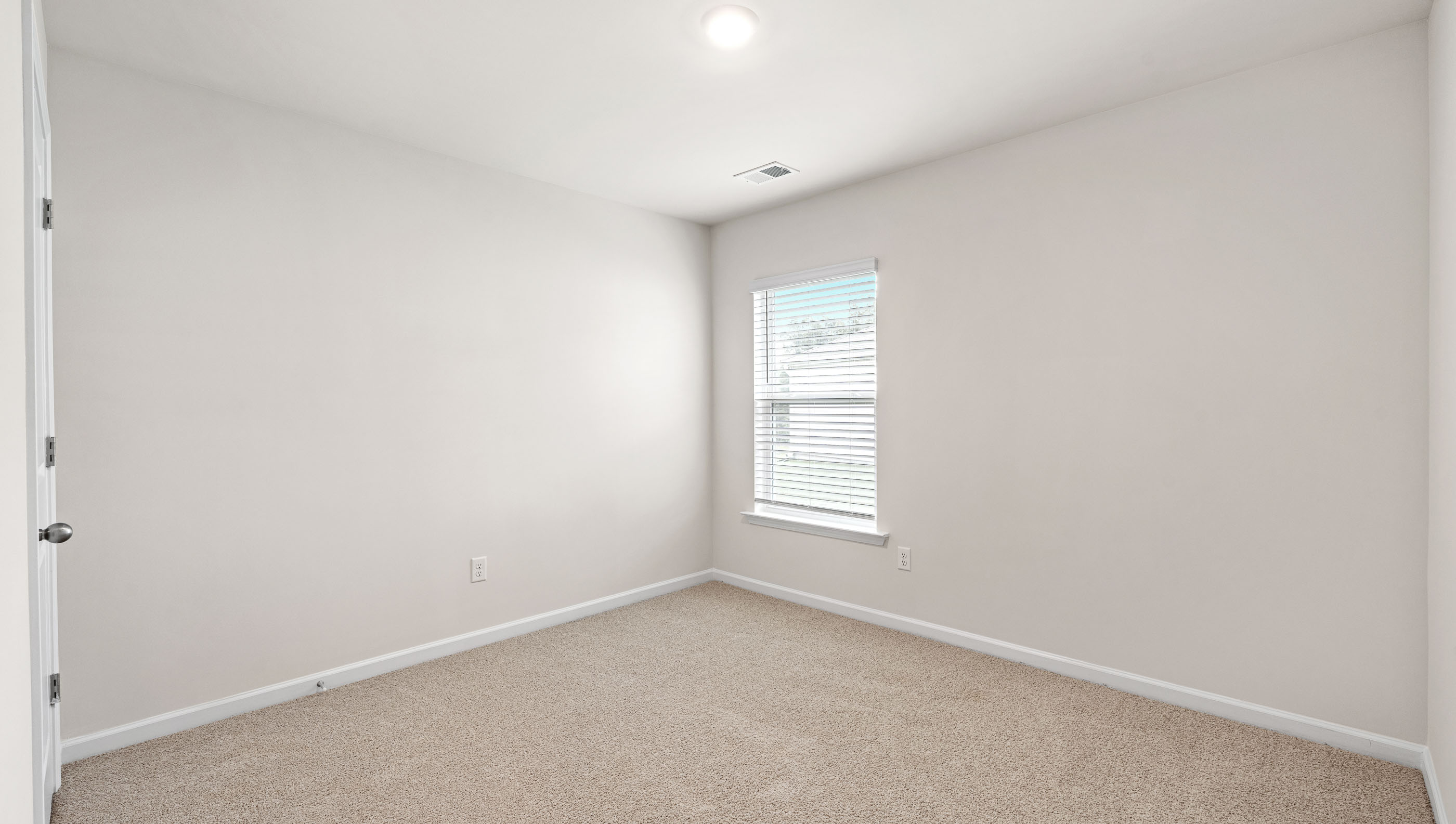 Bedroom with carpet and windows.