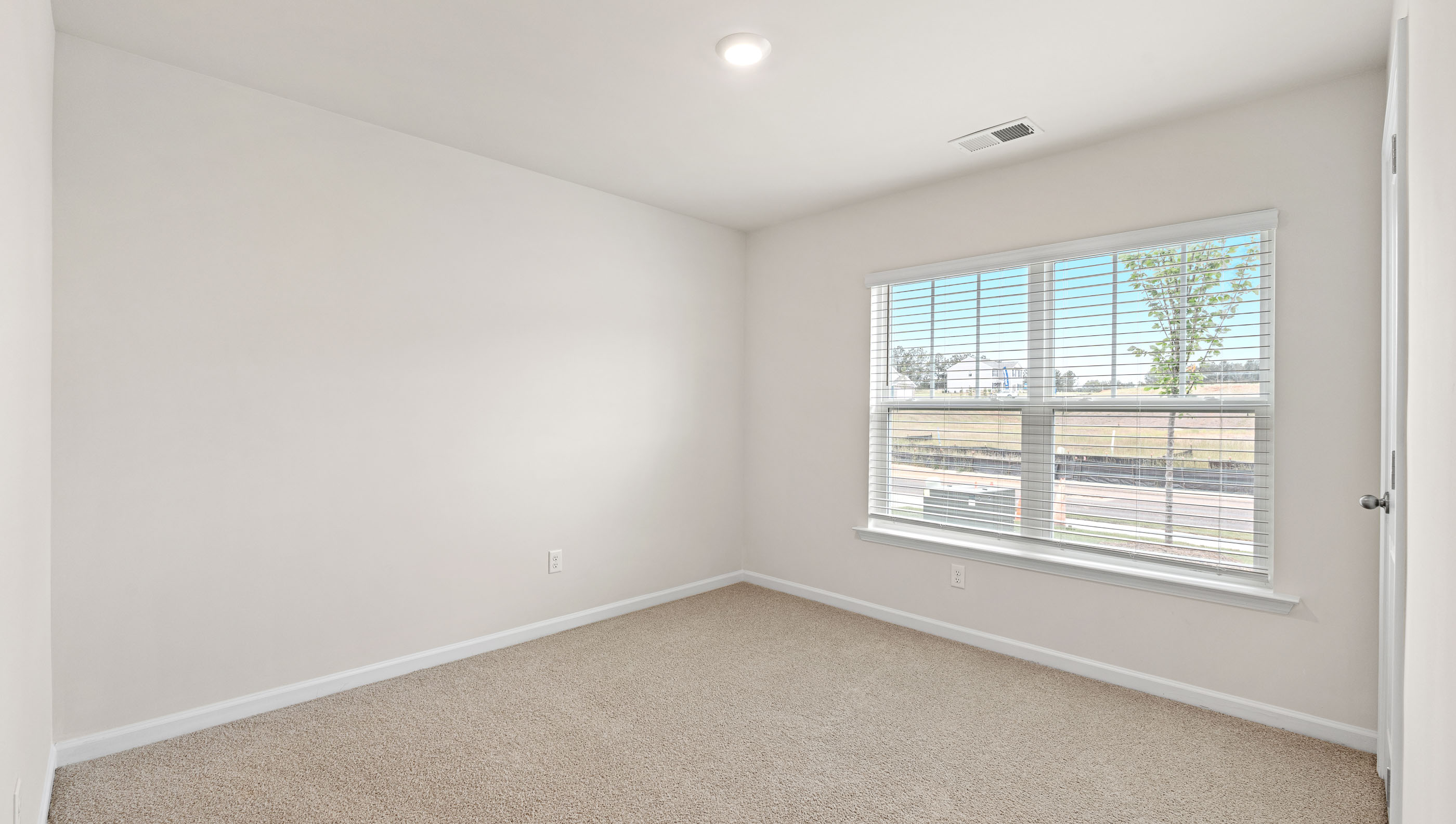 Bedroom with carpet and windows.