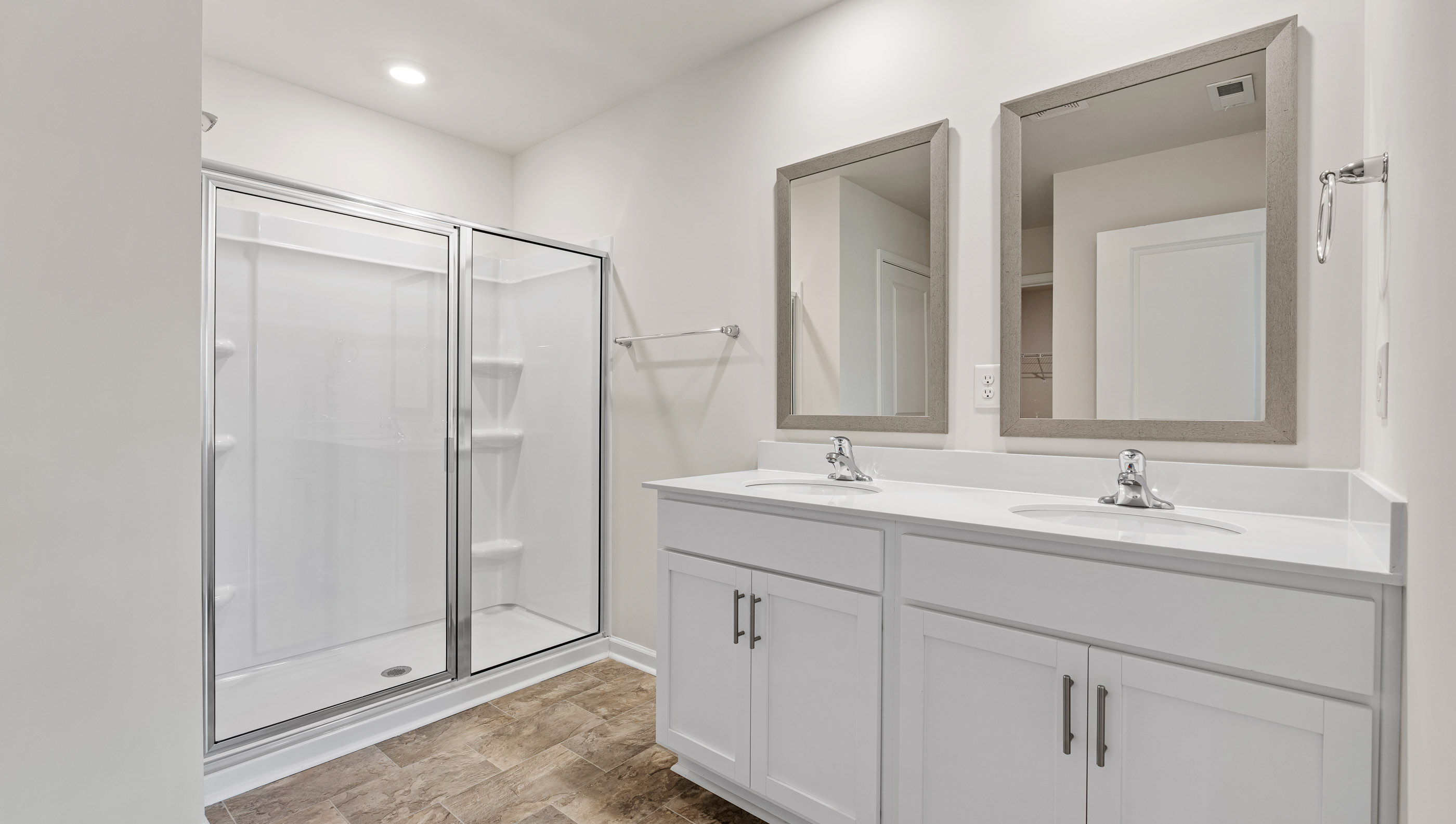Bathroom with double vanity and walk in shower.